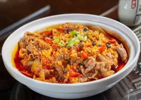 Thin sliced beef in a chili and egg broth topped with spring onion