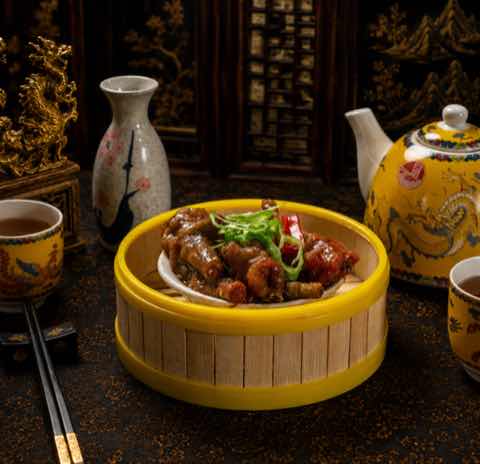 滷鳳爪裹上深色醬汁，撒上蔥花