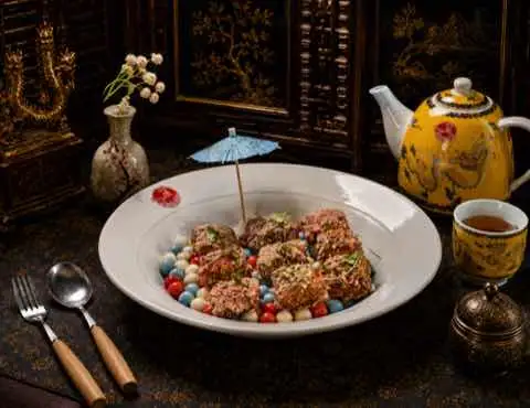 Crisp-crusted medallions plated over coloured pearls with a paper parasol