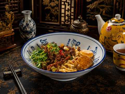 麵碗配孜然牛肉、青菜與一角蛋皮