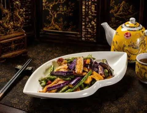 Eggplant and green beans stir-fried together on a leaf-shaped plate