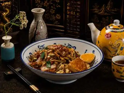 House noodle bowl with shredded meat, greens and egg