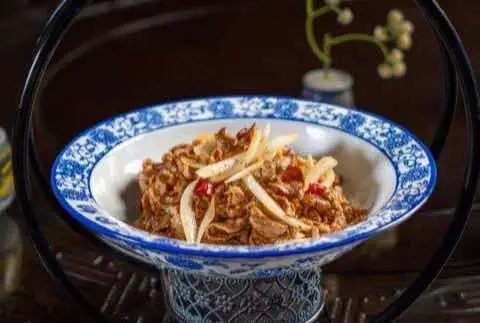 Shredded pork with bamboo shoots served in a blue and white bowl