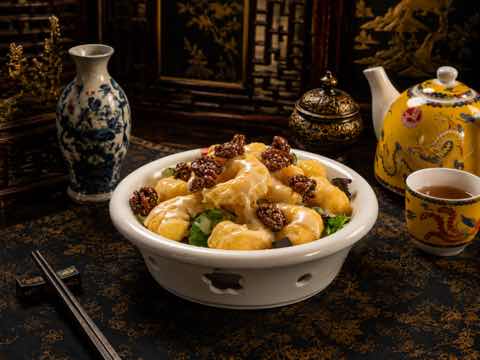 大蝦裹上乳白醬汁，配青豆與深色點綴