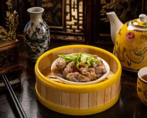 Steamed spare ribs with chili and spring onion in a bamboo steamer